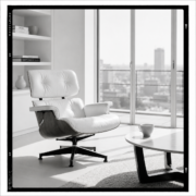 Fauteuil Eames coque blanche sur base noyer près d'une baie vitrée, table basse avec une tasse vide, lumière douce de fin de matinée, ambiance de calme après un échange